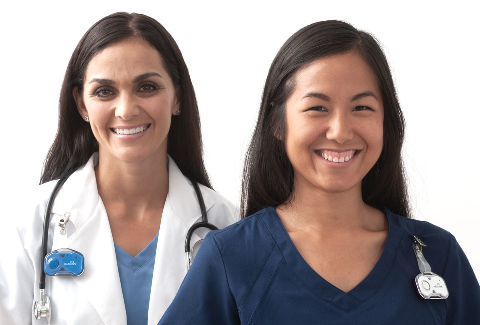 Doctor and nurse smiling at camera, wearing Midmark RTLS badges