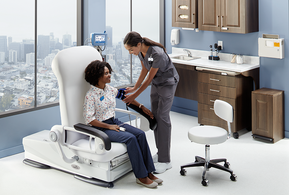 Nurse and patient in exam room capturing blood pressure reading