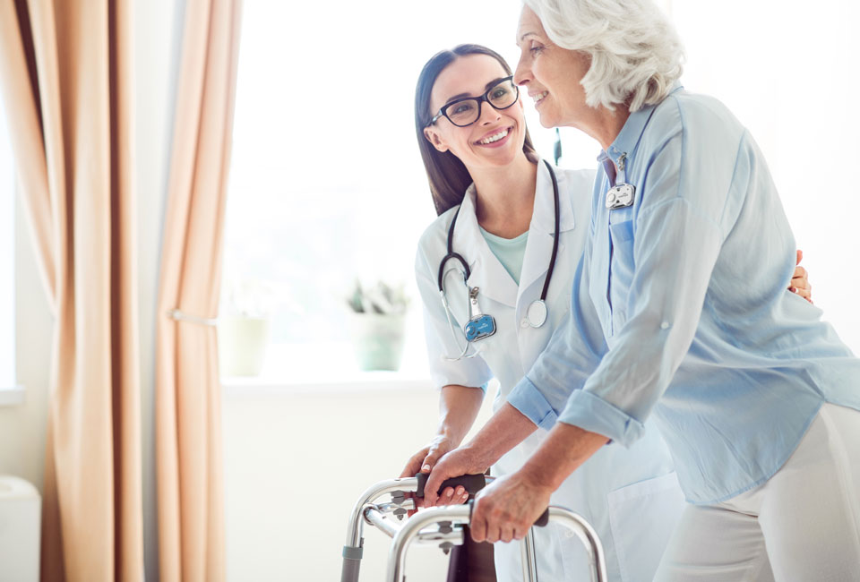 Nurse assisting a patient with a walker