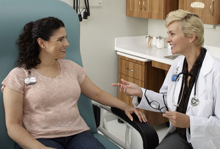 Doctor chatting with patient in exam chair