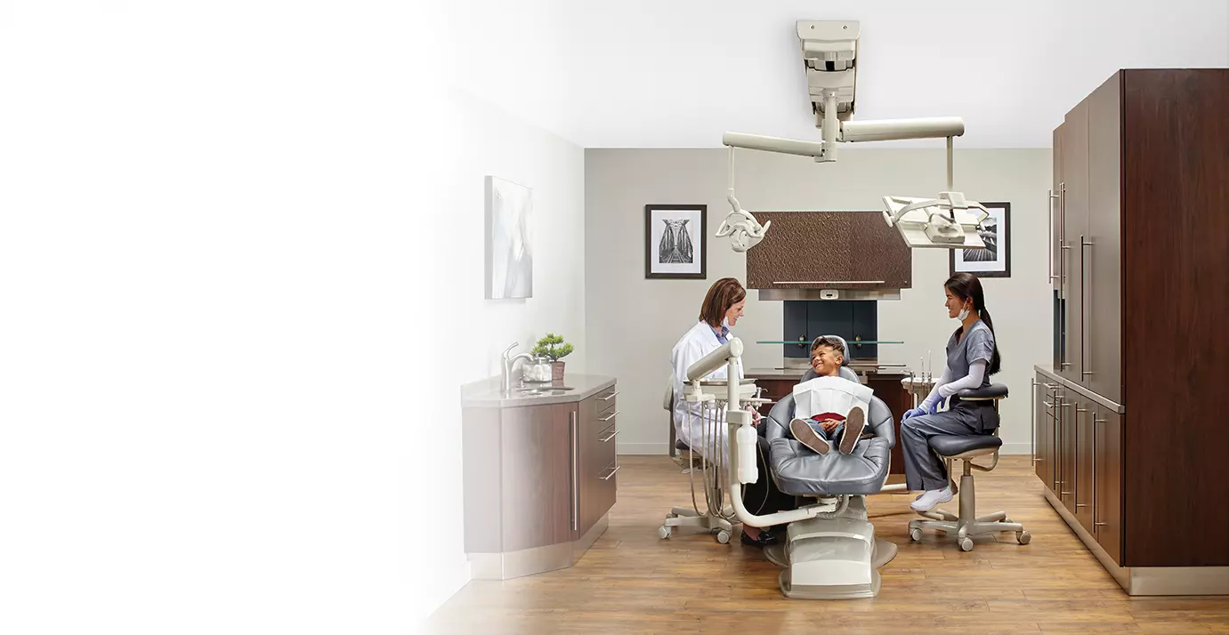 Dental staff with a young patient in a dental exam chair