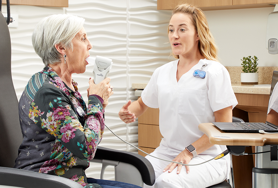 Nurse screening a patient in an exam room.