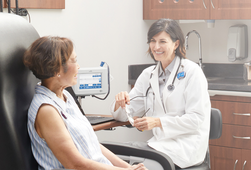 Smiling doctor in discussion with a patient in an exam room