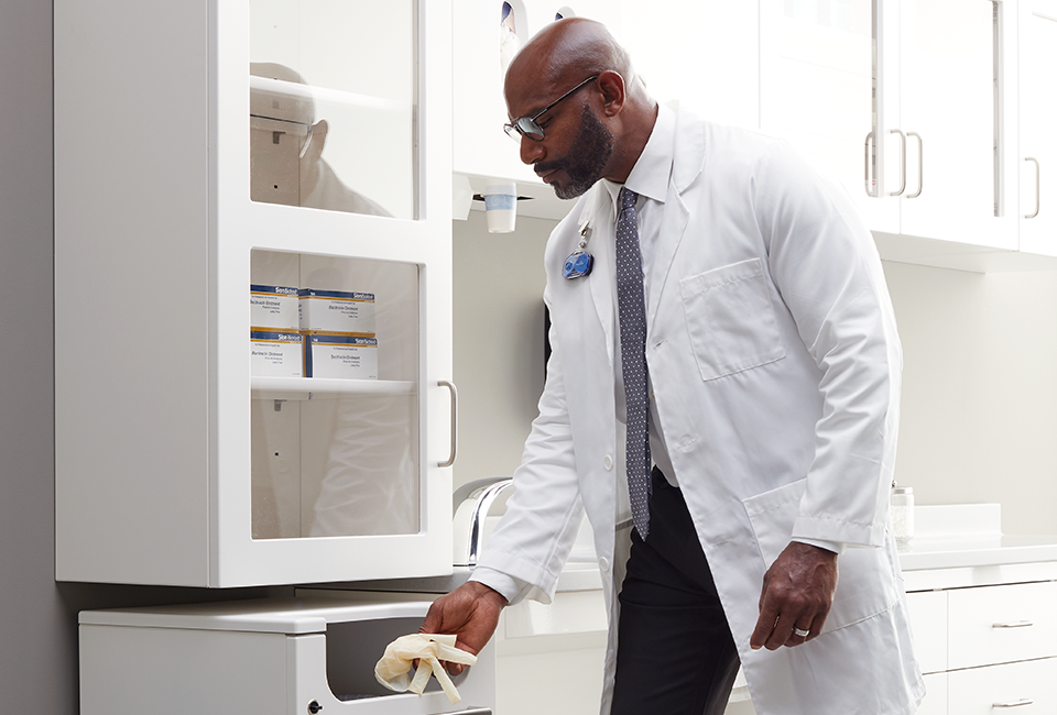 Doctor disposing of gloves in receptacle