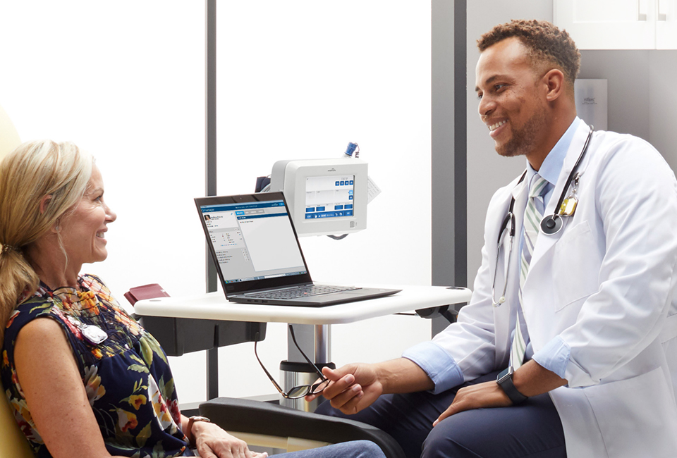 Doctor sitting with patient in exam room in conversation