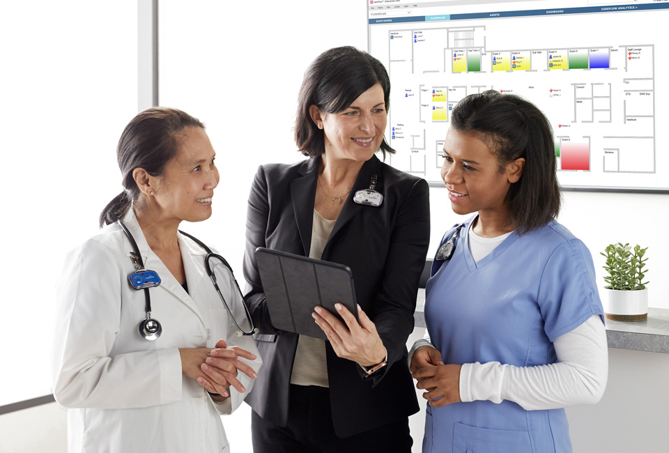 Acute nurses station with doctor, administrator and nurse reviewing reports.