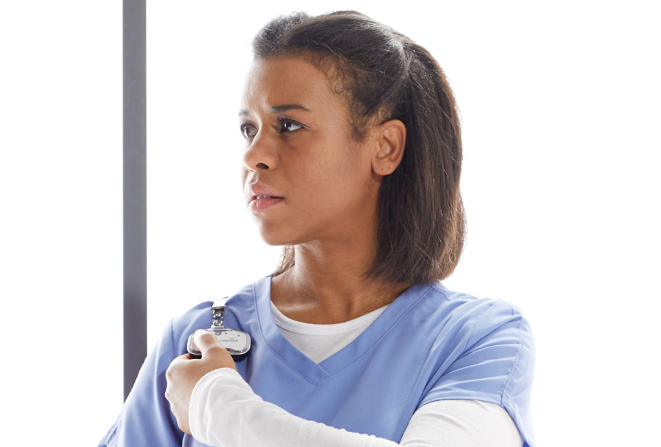 Nurse pushing a button on her RTLS badge