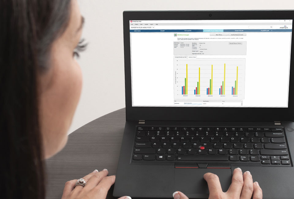 Caregiver looking at a laptop displaying patient charts