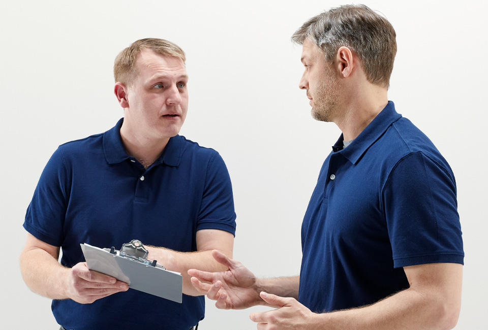 Man with clipboard looking concerned at another individual