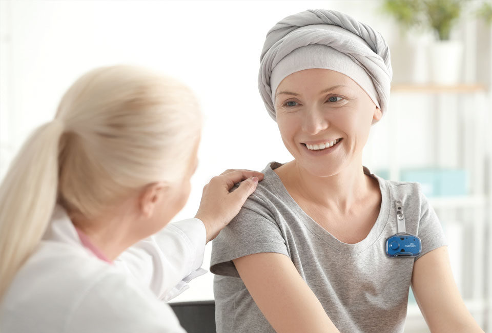 Doctor with hand placed on patient, wearing Midmark RTLS badge.