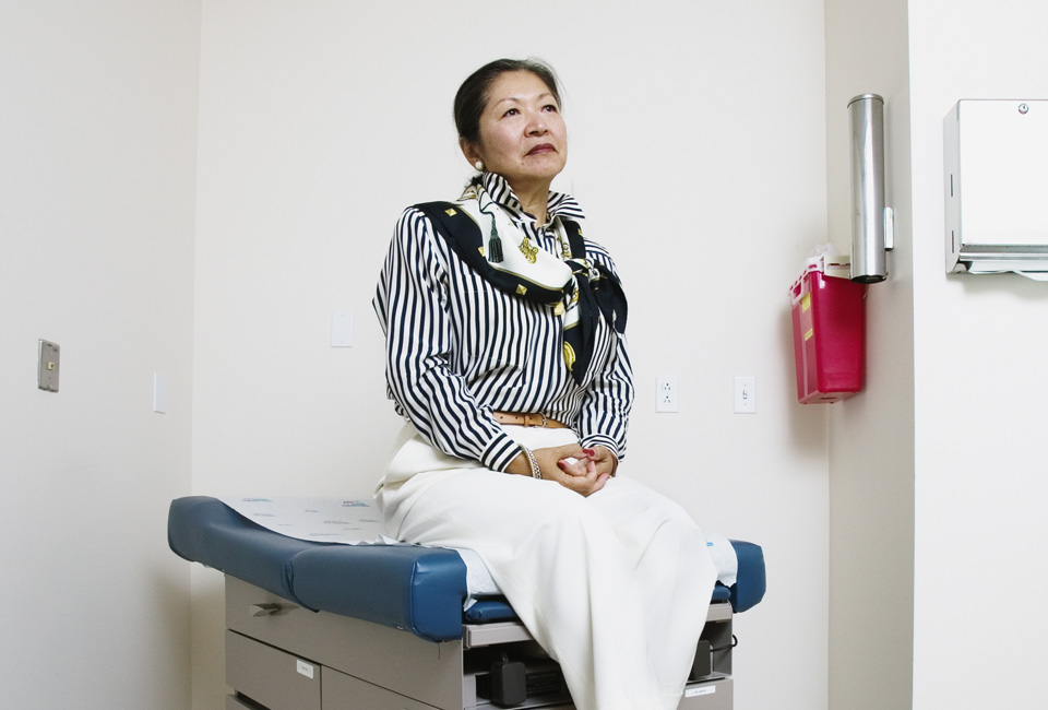 A patient waiting in an exam room on a Midmark exam table.