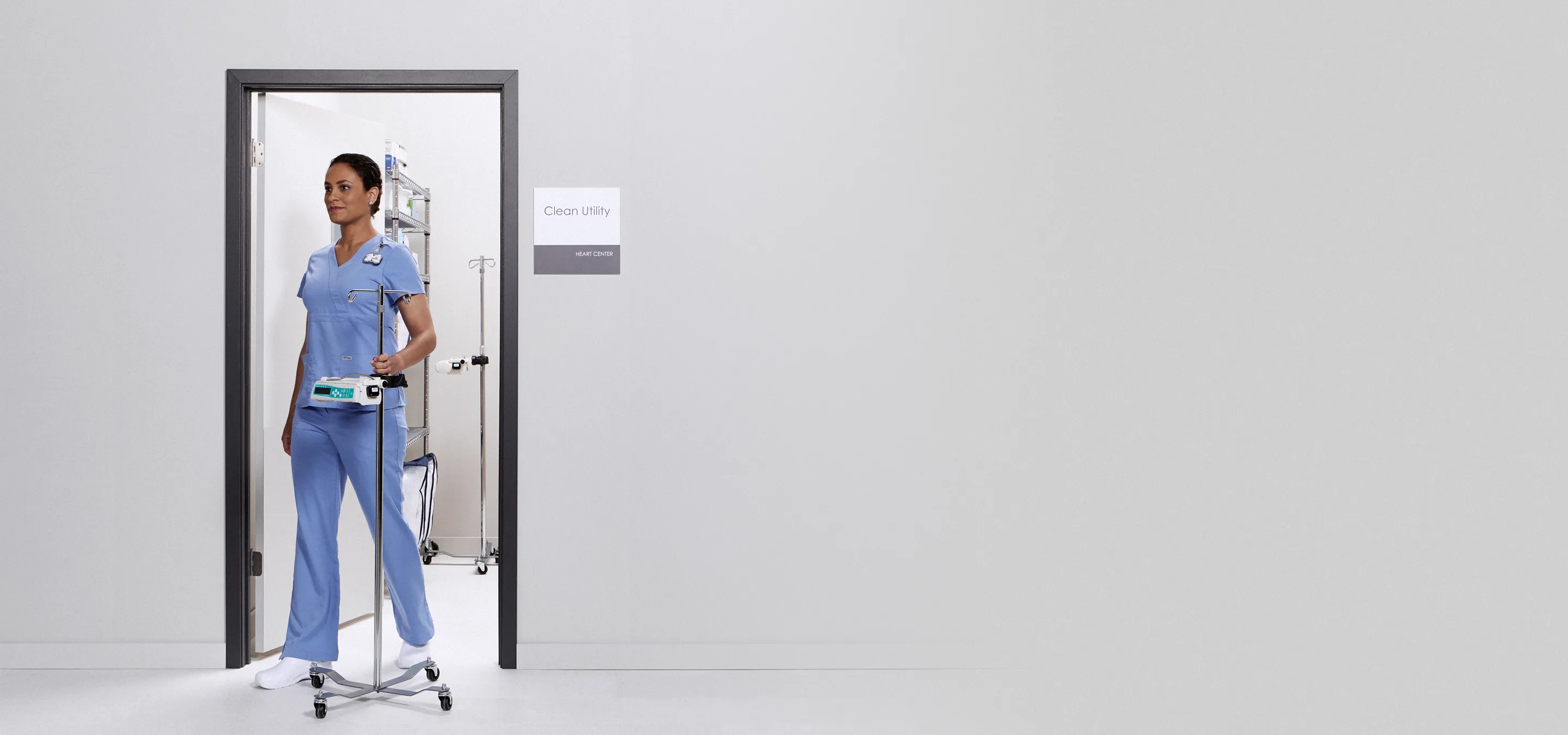 nurse entering room with rolling iv stand
