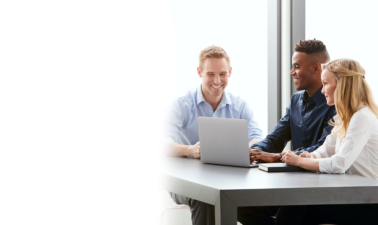 three midmark teammates sitting around laptop