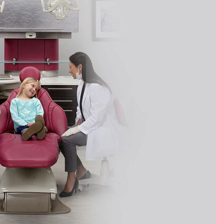 dentist talking to girl in dental chair