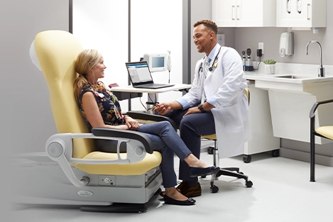 design-center-nav-aia-credit Doctor speaking with patient sitting in a Midmark 626 Exam Chair