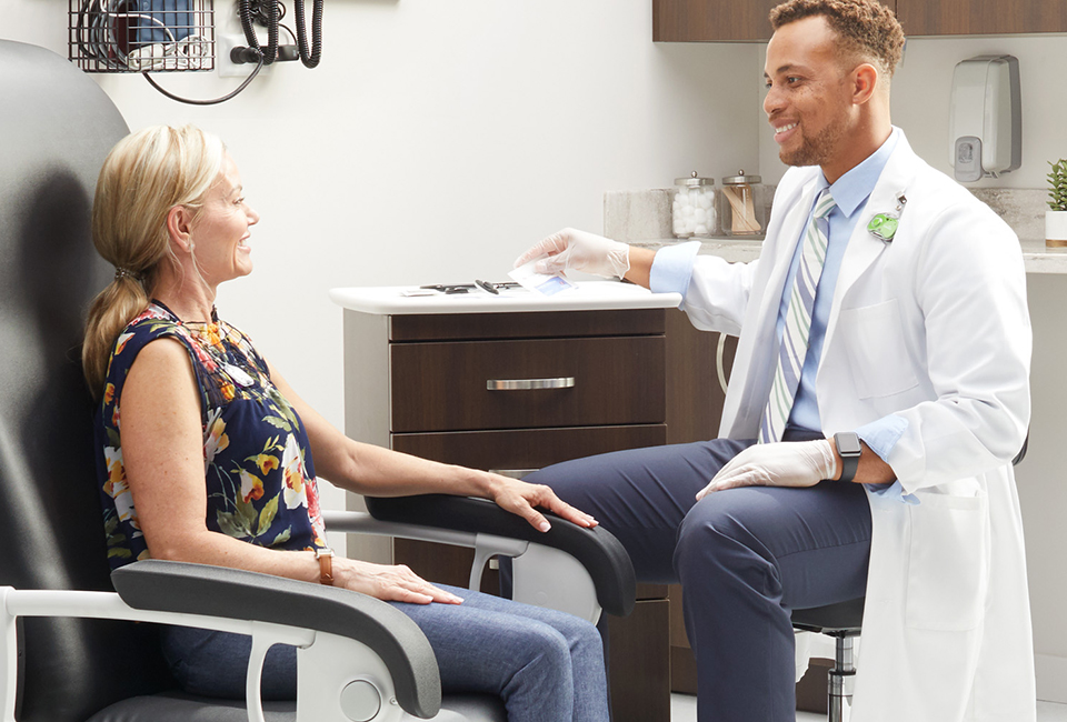 Doctor and patient in conversation near a patient treatment cabinet